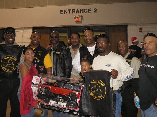 Soul Rydaz give away a toy at The Big Texas Toy Run.
